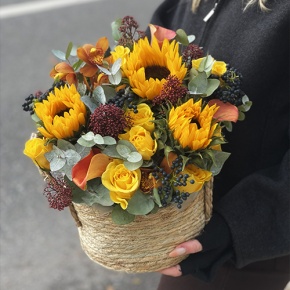 Композиция в сумке "Тональность" из подсолнухов, калл, ягод вибирнума, лимонных роз, скиммии и орхидеи в Пересвете